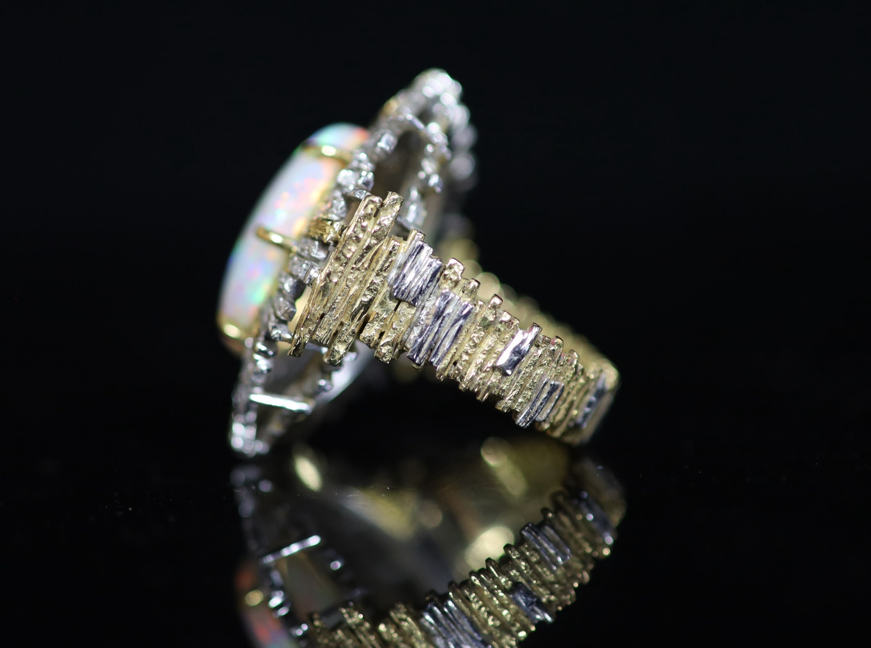 A 1970's? textured two colour 18ct gold and white opal set oval dress ring